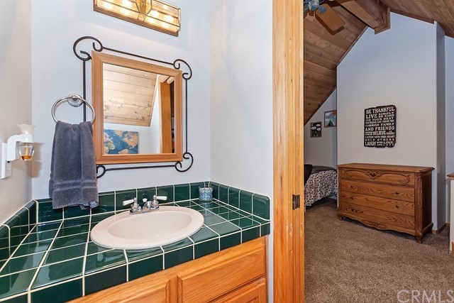 659 Blue Jay Canyon Road Blue Jay, CA 92317 - Photo 27 of 40 a bathroom with a sink a mirror and a shower