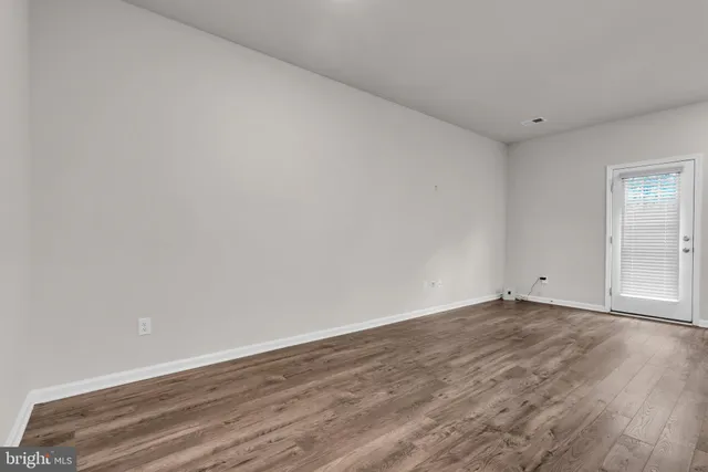 a view of kitchen with center island and stainless steel appliances with wooden floor