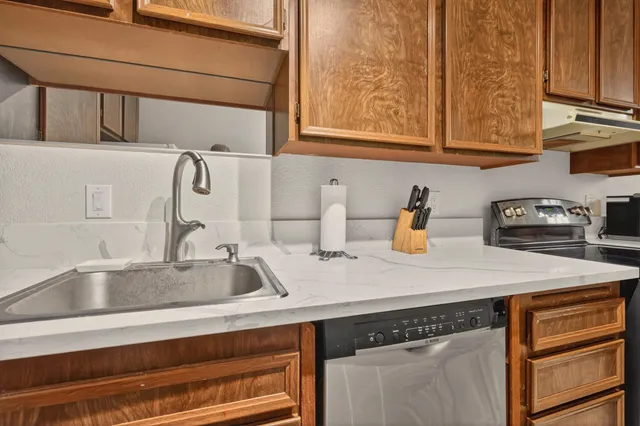 a kitchen with stainless steel appliances granite countertop a sink and cabinets