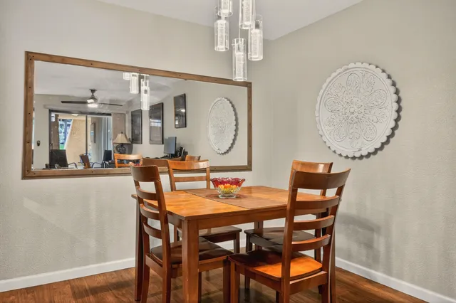 a dining room with wooden floor a glass table and chairs