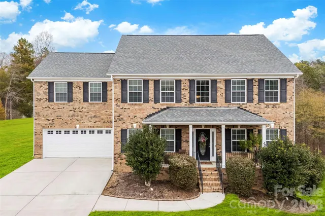 a front view of a house with yard and green space