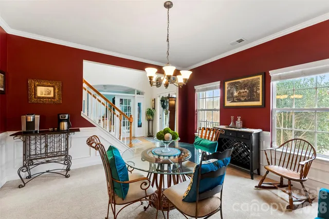 a dining room with furniture a floor to ceiling window and a flat screen tv
