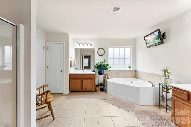 a view of a bathroom with sink mirror and shower