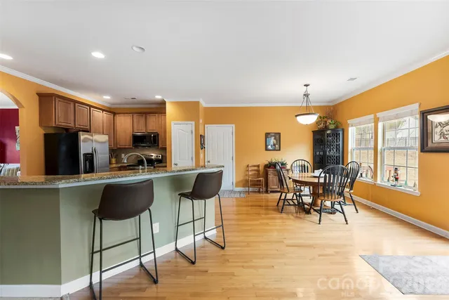 a kitchen with stainless steel appliances granite countertop a sink stove refrigerator and cabinets