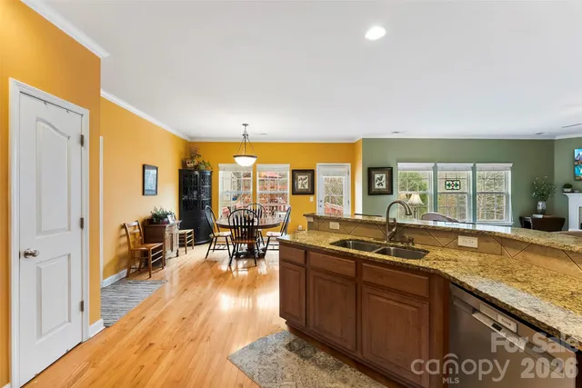 a kitchen with a stove a sink a dining table and chairs