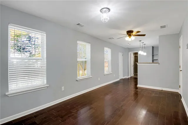 a view of an empty room with a window and wooden floor