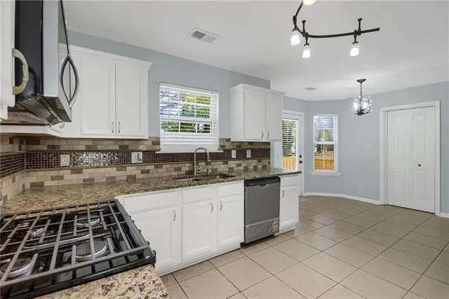 a kitchen with granite countertop a sink stove and cabinets