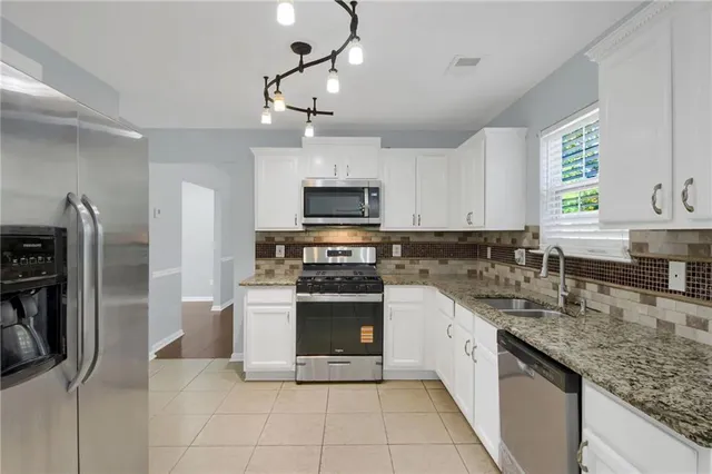 a large kitchen with cabinets stainless steel appliances and a counter space