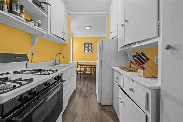 a kitchen with stainless steel appliances a stove and a wooden floor