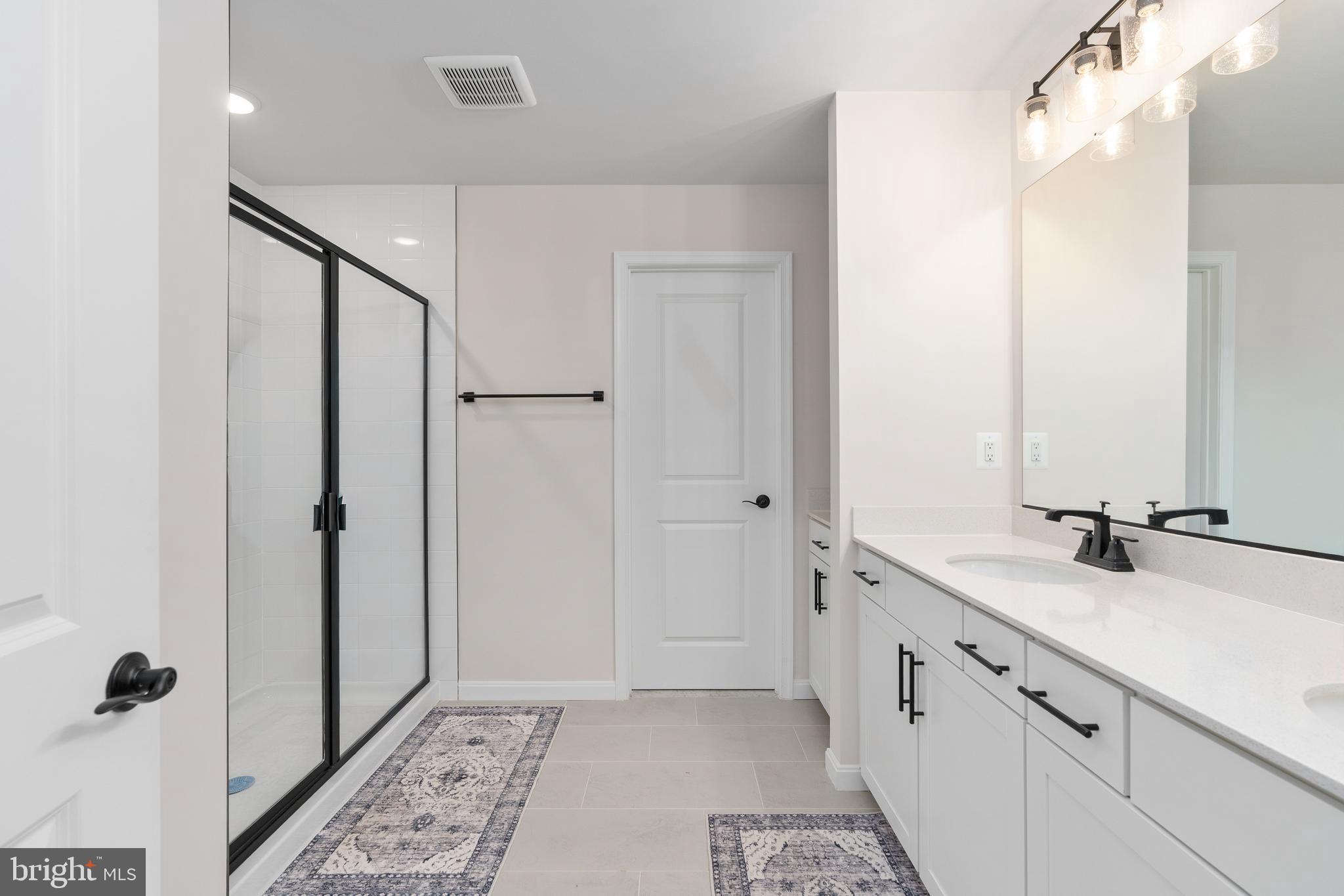 35514 Aspen Way Locust Grove, VA 22508 - Photo 36 of 56 a bathroom with a double vanity sink a mirror and a shower