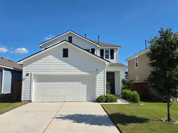 a front view of a house with a yard and garage