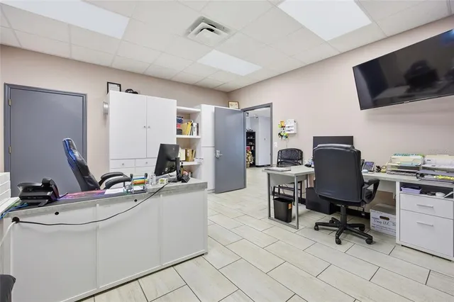 a work room with furniture a rug and a view of living room