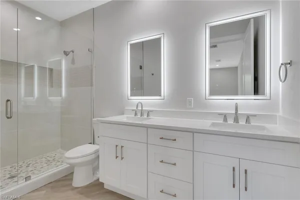 a bathroom with a granite countertop sink a toilet and a mirror