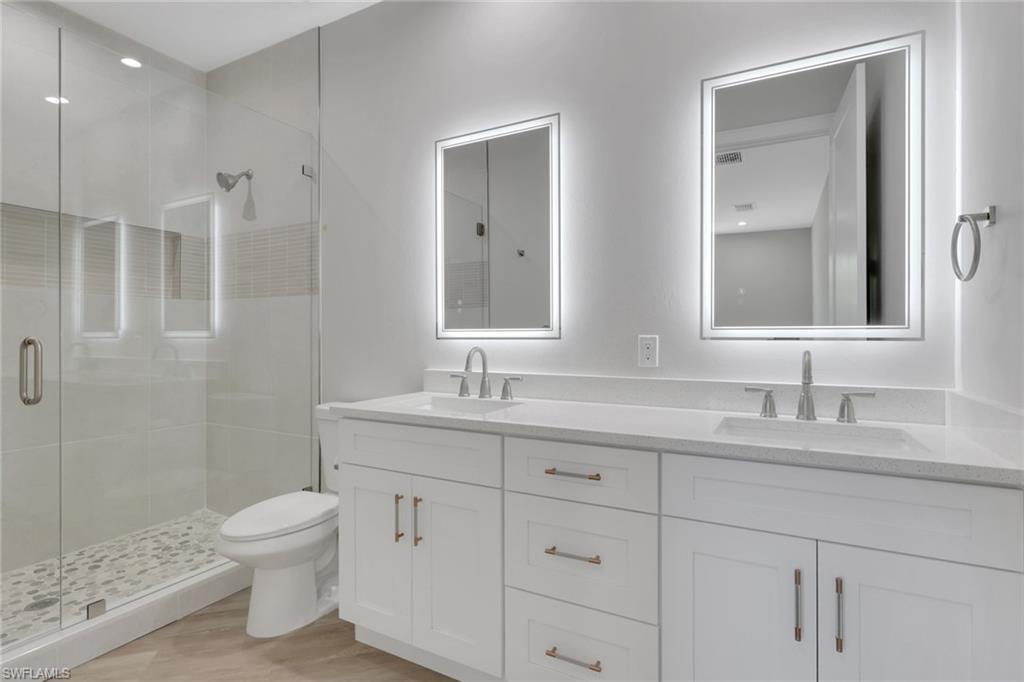 3500 Croton Road, Unit 102 Naples, FL 34104 - Photo 14 of 27 a bathroom with a granite countertop sink a toilet and a mirror