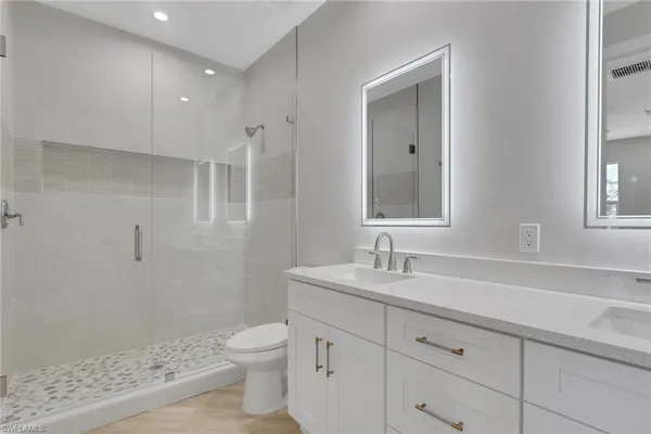 a bathroom with a sink a toilet and shower