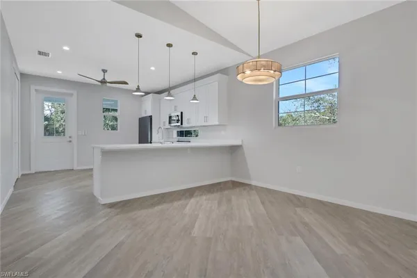 a large kitchen with granite countertop a stove a sink a window and a wooden floor