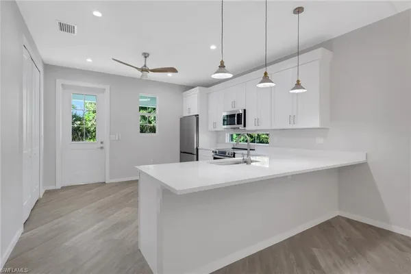 a kitchen with kitchen island a sink and a stove top oven