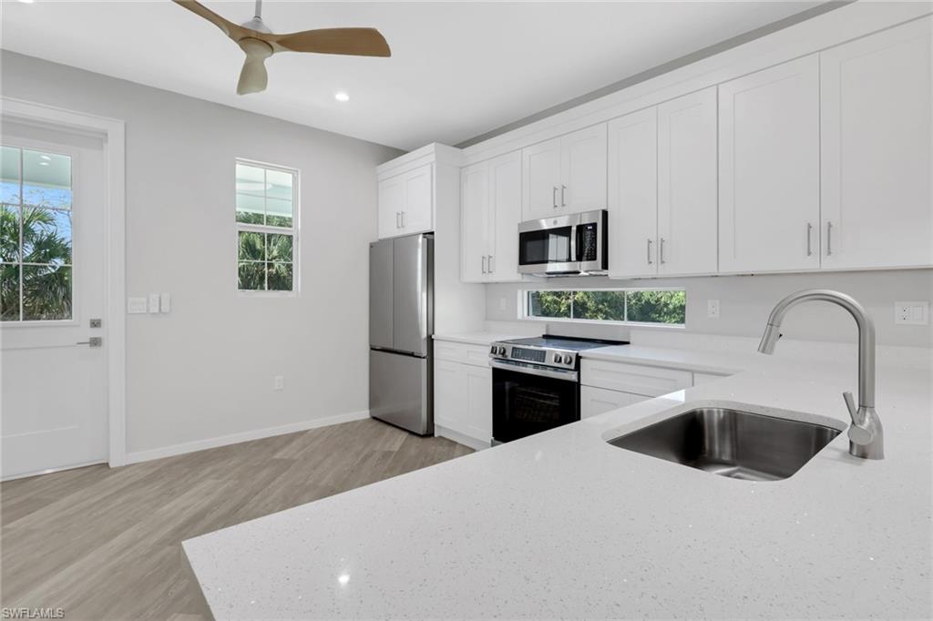 3500 Croton Road, Unit 102 Naples, FL 34104 - Photo 8 of 27 a kitchen with stainless steel appliances a refrigerator sink and cabinets