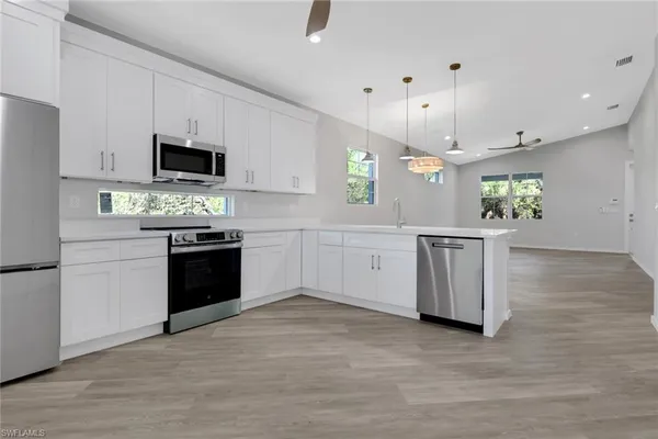 a kitchen with a sink cabinets and wooden floor