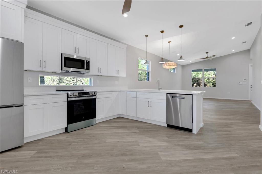 3500 Croton Road, Unit 102 Naples, FL 34104 - Photo 9 of 27 a kitchen with a sink cabinets and wooden floor