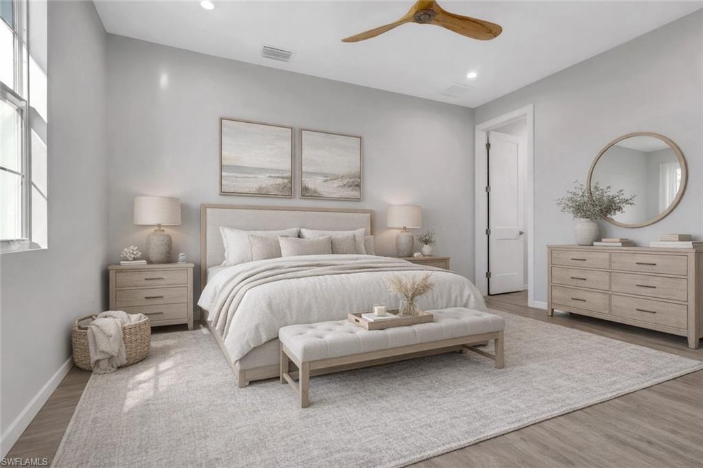 3500 Croton Road, Unit 102 Naples, FL 34104 - Photo 10 of 27 a bedroom with a bed and a chandelier