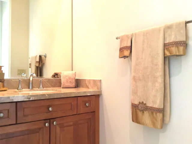 a en suite bathroom with a granite countertop sink and a mirror