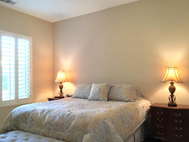 a bedroom with a bed and a lamp