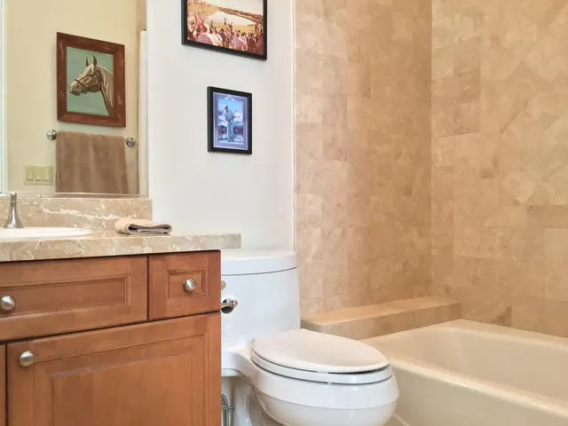 a bathroom with a granite countertop toilet sink and a bathtub