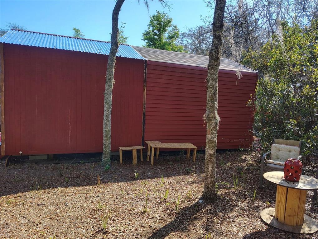 1873 West Foxglove Road Avon Park, FL 33825 - Photo 4 of 14 a view of a backyard with a chair and potted plants
