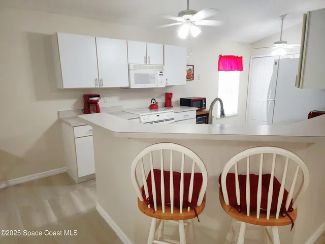 a kitchen with stainless steel appliances granite countertop a sink microwave and cabinets