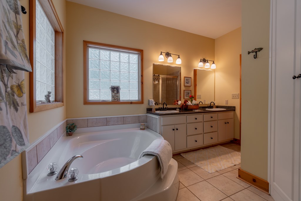 636 Kings Gap Road Hamilton, GA 31811 - Photo 27 of 63 a bathroom with a tub a double vanity sink and mirror