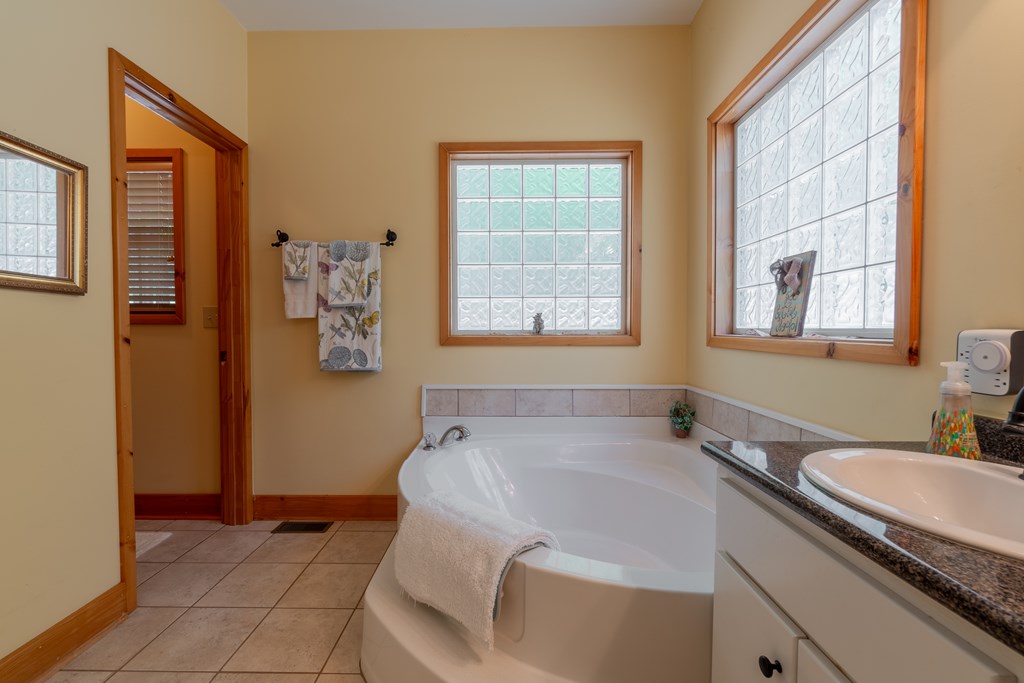 636 Kings Gap Road Hamilton, GA 31811 - Photo 28 of 63 a bathroom with a granite countertop sink and a bathtub
