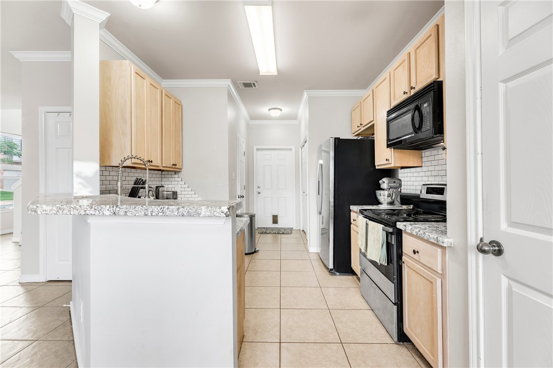 1425 West Villa Maria Road, Unit 1004 Bryan, TX 77801 - Photo 8 of 23 a kitchen with stainless steel appliances granite countertop a refrigerator and a stove top oven