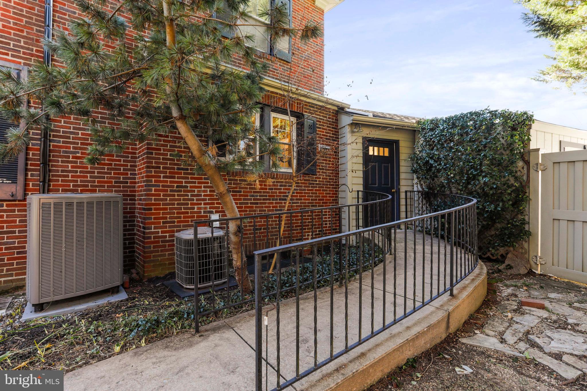 305 College Place Frederick, MD 21701 - Photo 53 of 71 a view of a brick house with a small yard and wooden fence