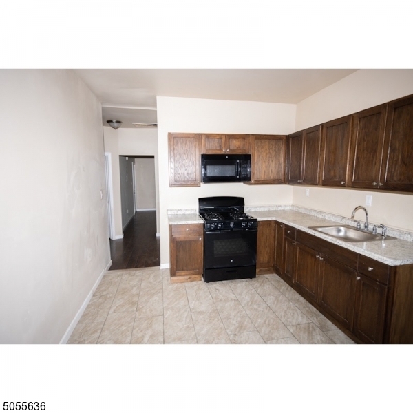 54 3rd Street, Unit 3 Newark, NJ 07107 - Photo 4 of 12 a kitchen with a sink a stove and cabinets