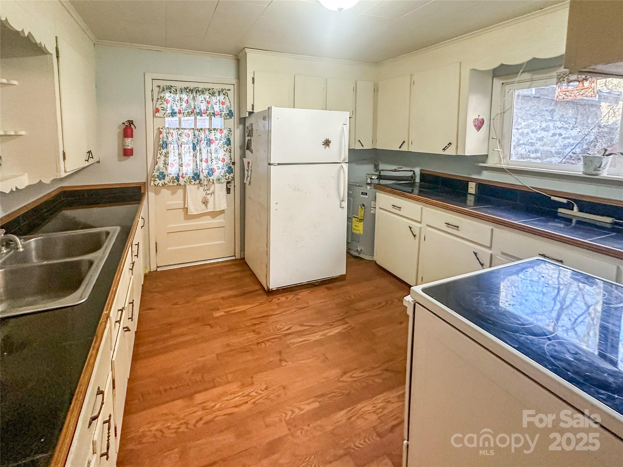 2812 Bald Mountain Road Burnsville, NC 28714 - Photo 25 of 38 a kitchen with a refrigerator sink and cabinets
