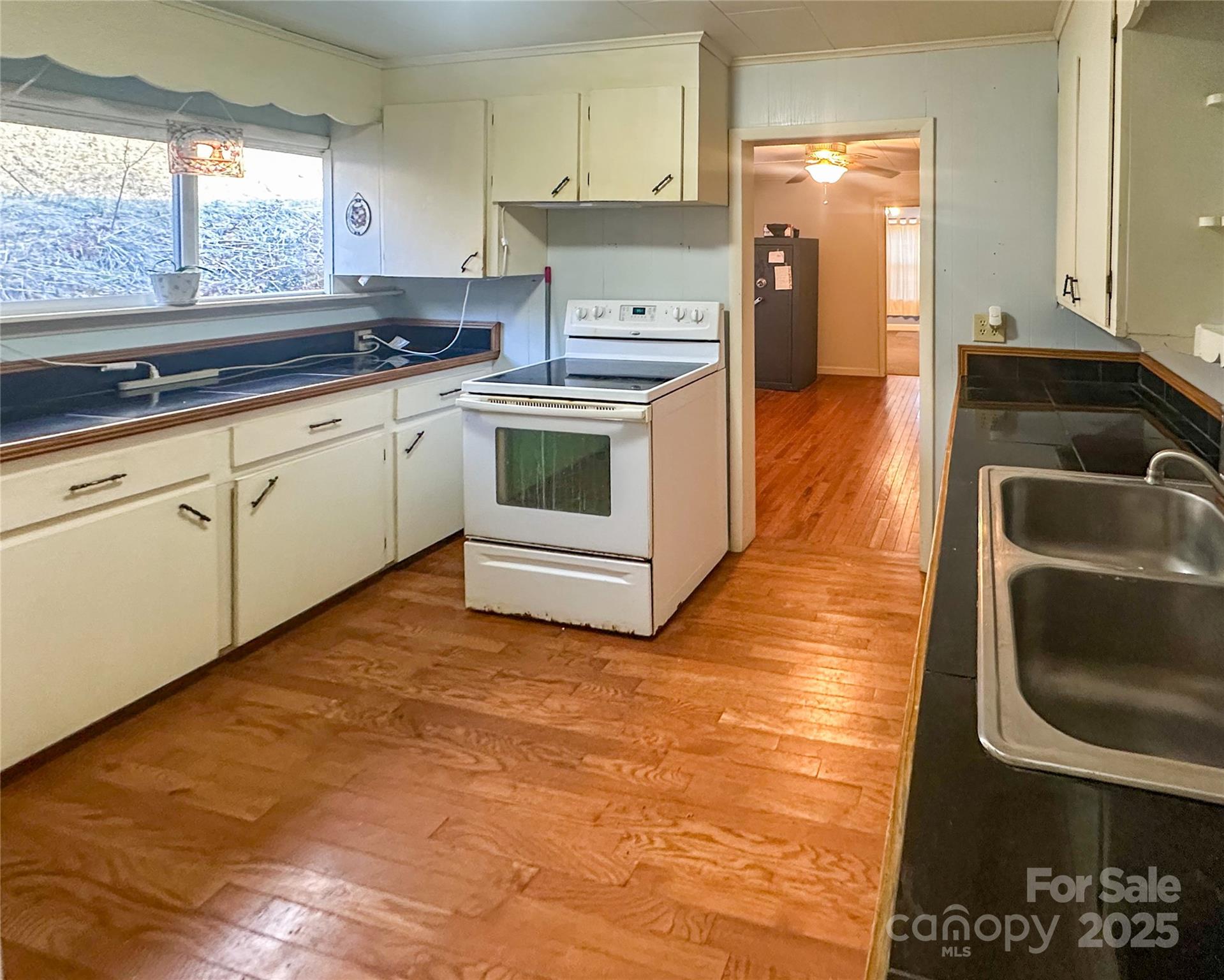 2812 Bald Mountain Road Burnsville, NC 28714 - Photo 26 of 38 a kitchen with a sink stove and cabinets