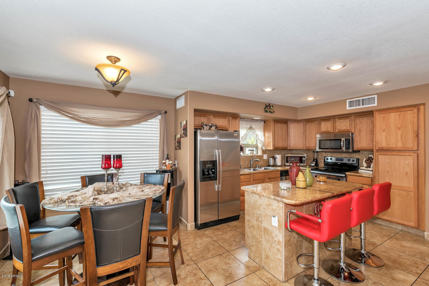 28615 North Nobel Road Phoenix, AZ 85085 - Photo 6 of 27 a kitchen with a dining table chairs and refrigerator