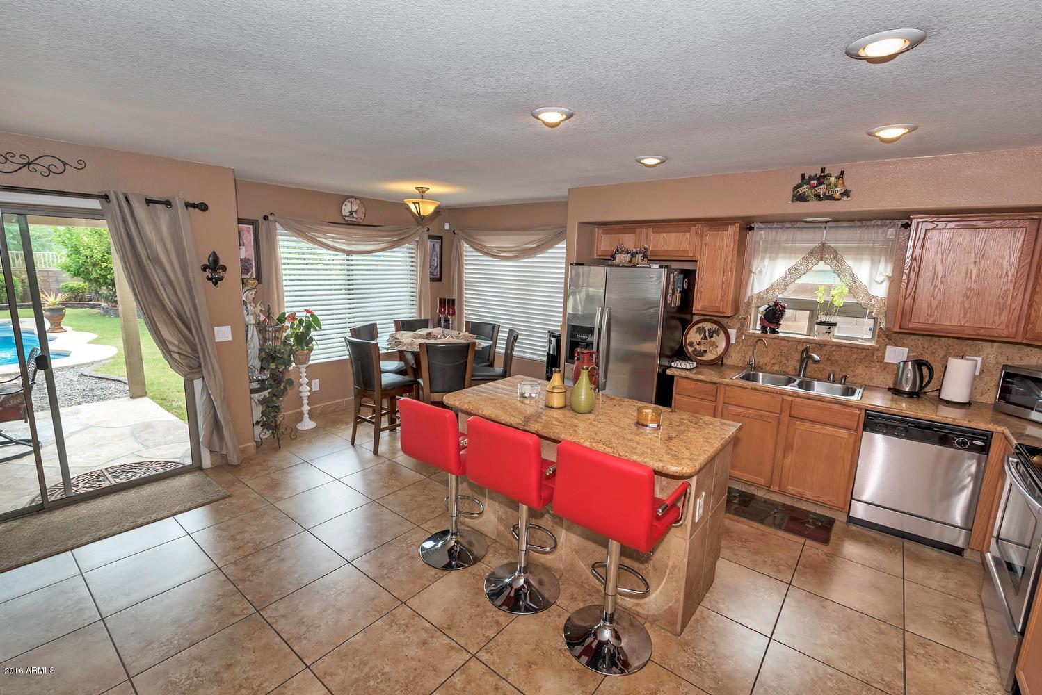 28615 North Nobel Road Phoenix, AZ 85085 - Photo 7 of 27 a kitchen with a sink refrigerator and chairs