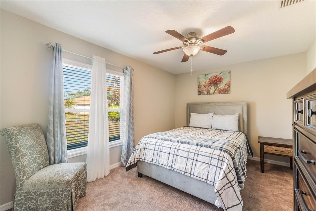 15 Raeland Lane Palm Coast, FL 32164 - Photo 11 of 13 a bedroom with a bed and a chandelier