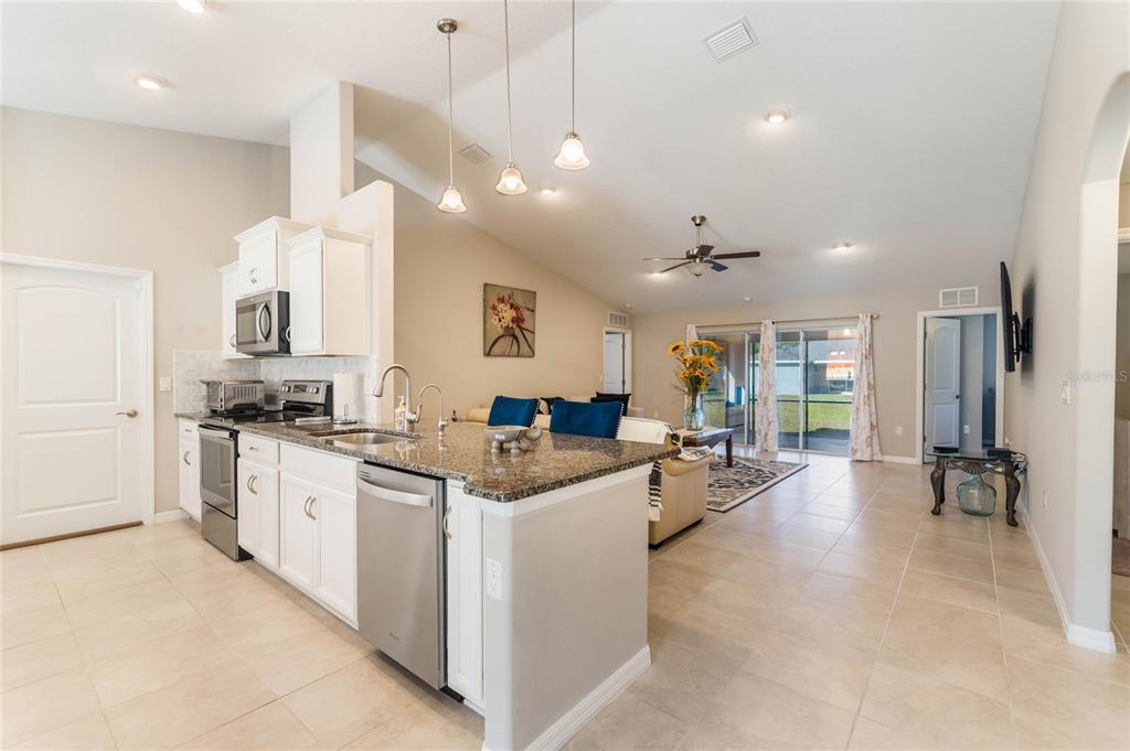 15 Raeland Lane Palm Coast, FL 32164 - Photo 2 of 13 a kitchen with stainless steel appliances kitchen island granite countertop a lot of counter top and living room