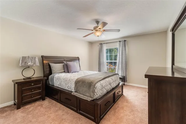 a spacious bedroom with a bed and dresser with wooden floor