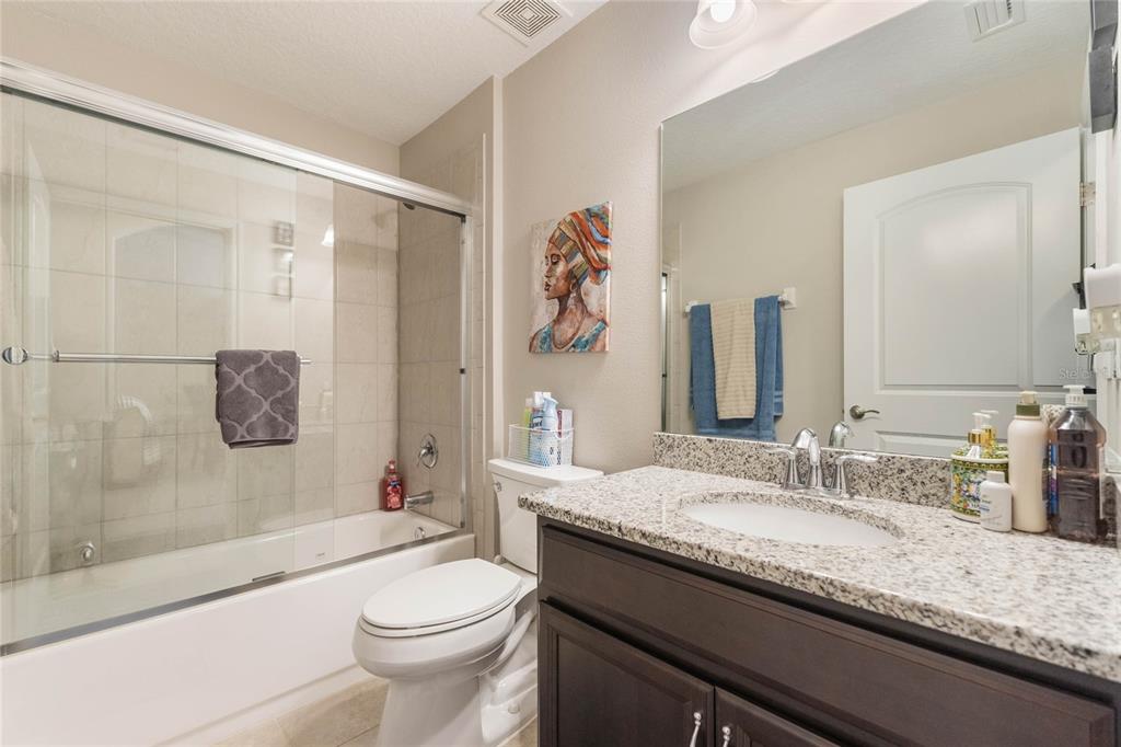 15 Raeland Lane Palm Coast, FL 32164 - Photo 10 of 13 a bathroom with a granite countertop toilet a sink a mirror a bathtub and shower