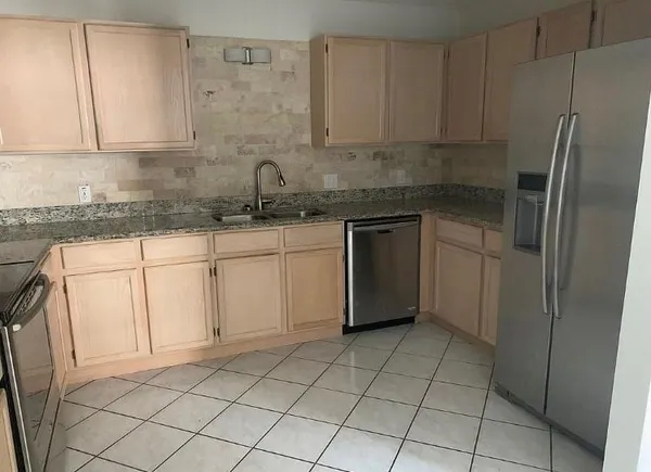 a kitchen with a sink a refrigerator and cabinets