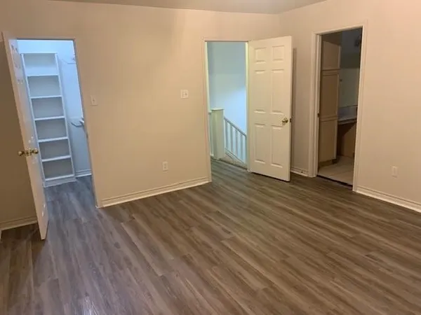 an empty room with wooden floor and closet