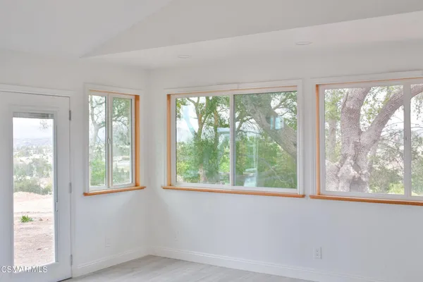 a view of an empty room with large windows