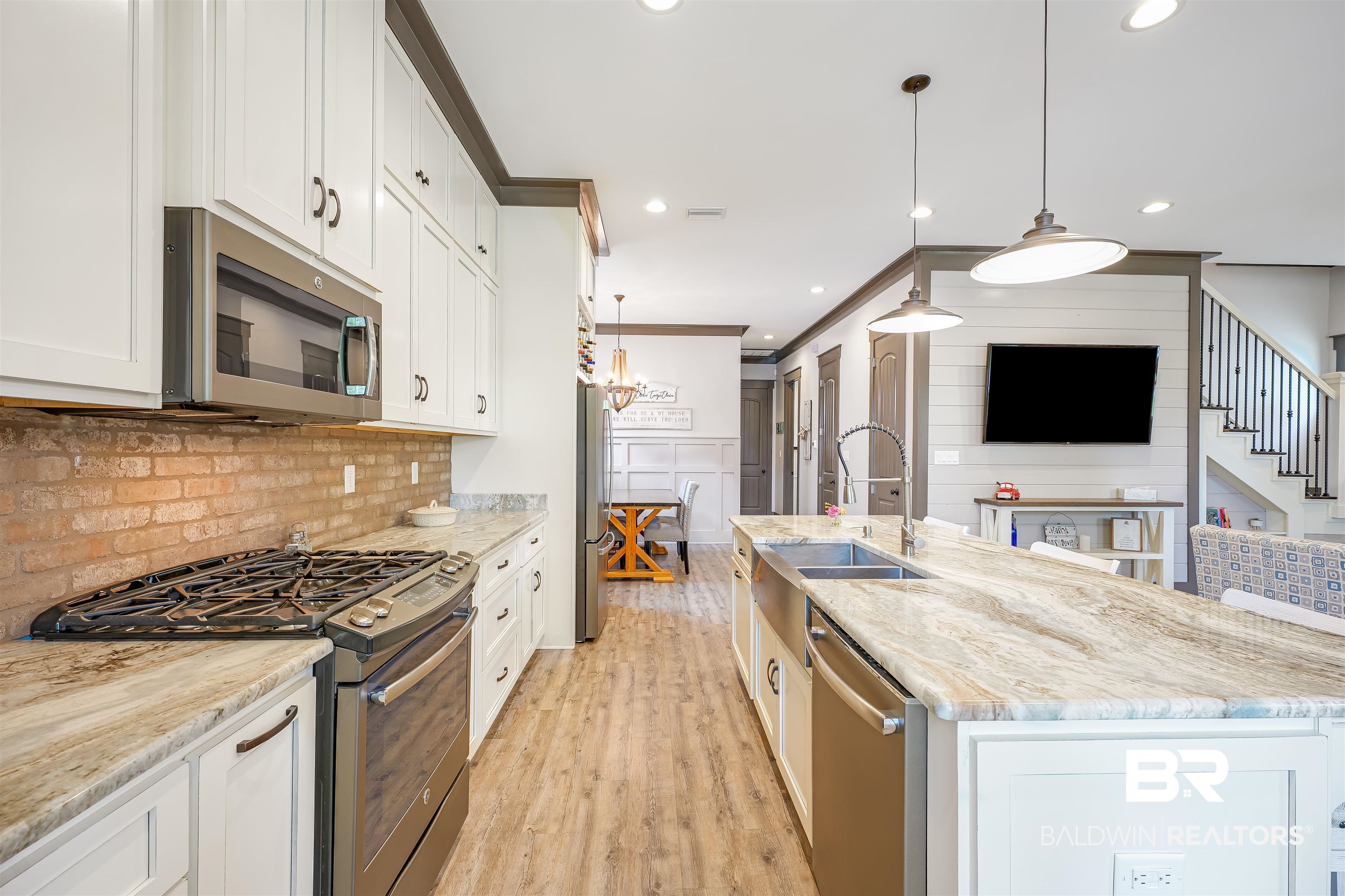 1119 Pink Poppy Lane Foley, AL 36535 - Photo 21 of 38 Kitchen featuring appliances with stainless steel finishes, decorative light fixtures, light stone counters, crown molding, and recessed lighting