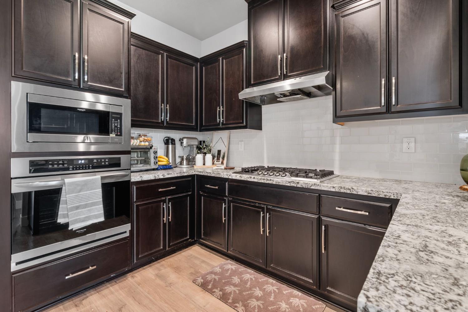 1847 Outrigger Lane Lathrop, CA 95330 - Photo 13 of 54 a kitchen with stainless steel appliances granite countertop wooden cabinets a stove top oven a sink and dishwasher