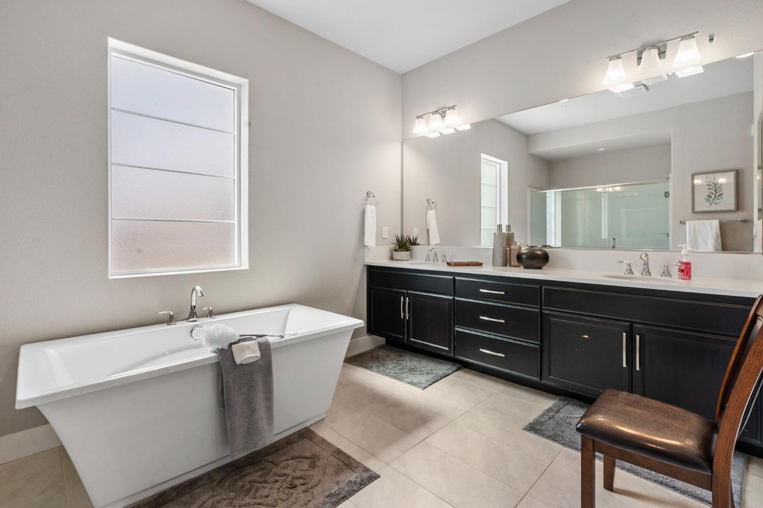 1847 Outrigger Lane Lathrop, CA 95330 - Photo 32 of 54 a bathroom with a tub a double vanity sink and a window