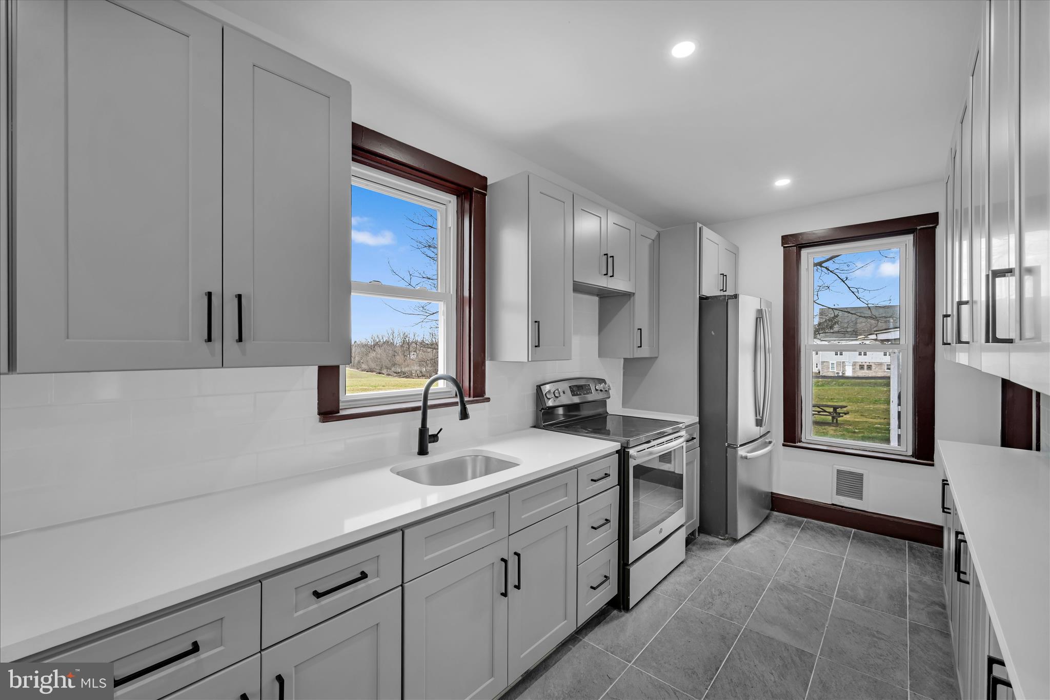 2132 Main Street Lititz, PA 17543 - Photo 13 of 44 a spacious bathroom with a double vanity sink a mirror and a bathtub next to a window
